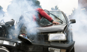 Bewusstloser Motorradfahrer liegt auf der Motorhaube.