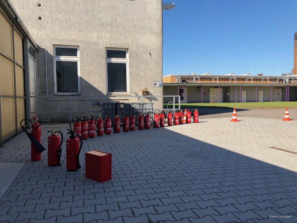 Aussenfläche speziell für ein Feuerlöschtraining vorbereitet. Zahlreiche Feuerlöscher für das Löschtraining stehen bereit.
