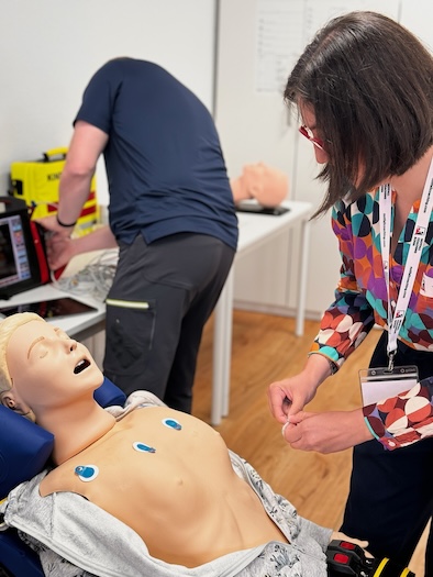 Notärztin klebt im ACLS Provider Kurs ein EKG am ansprechbaren Patienten.