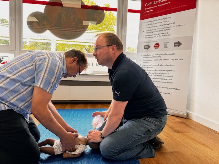 Notarzt und Sanitäter trainieren Reanimation während BLS Provider Kurs der AHA.