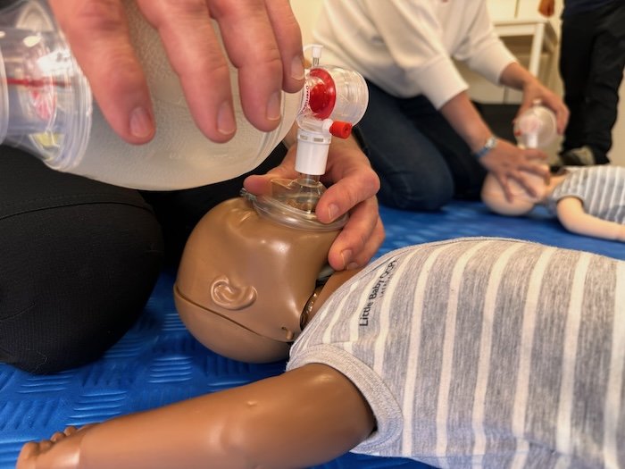 Teilnehmer in einem zertifizierten BLS Provider Kurs trainiert die Beatmung am Säugling.