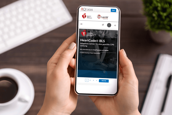 Jemand hält das Smatphone in der Hand und lernt für den HeartCode BLS Kurs.