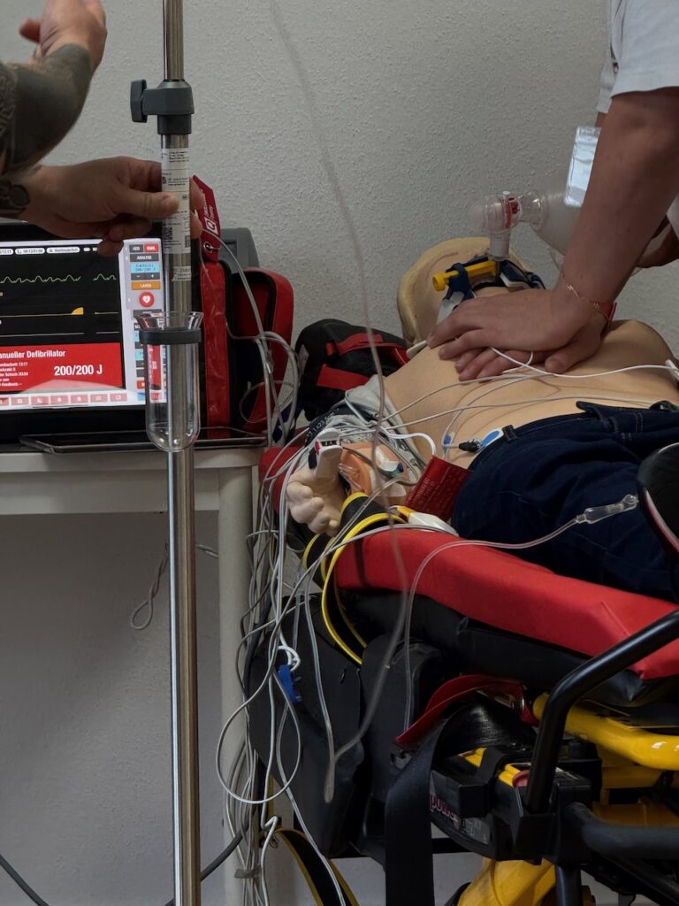 ACLS Training Reanimation mit EKG, Sauerstoff und laufender Herzdruckmassage.